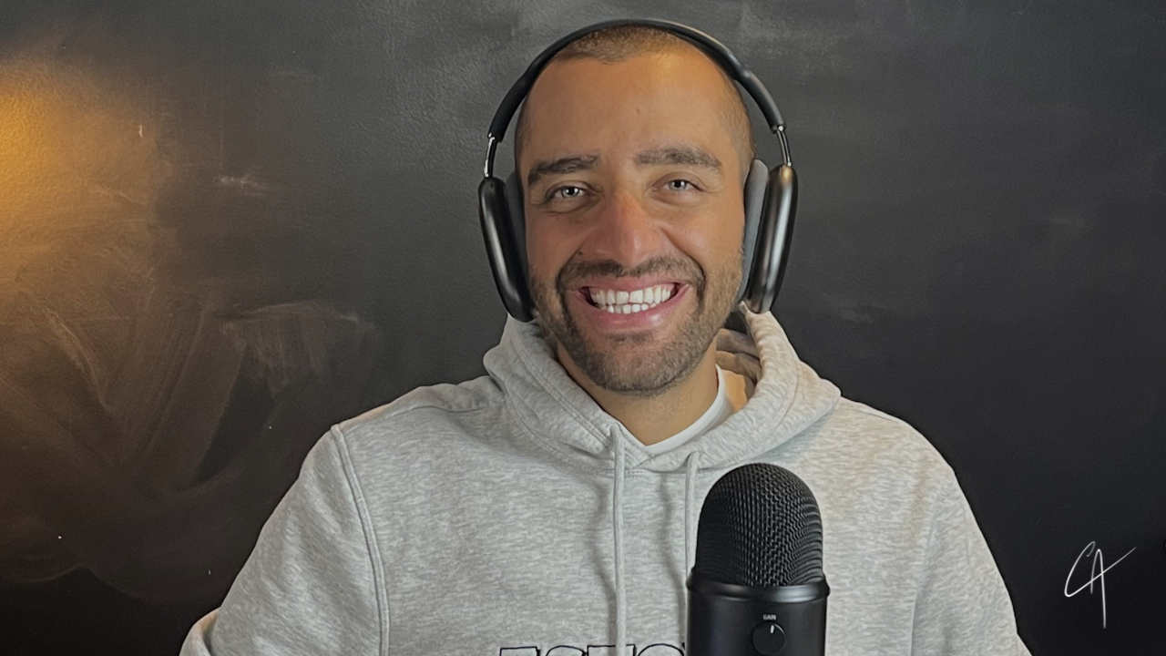 Carlos Agami speaking with a microphone in hand during a recording